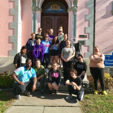 Members of various Greek like organizations from SUNY Oswego stand on the front steps of the Richardson-Bates House Museum.