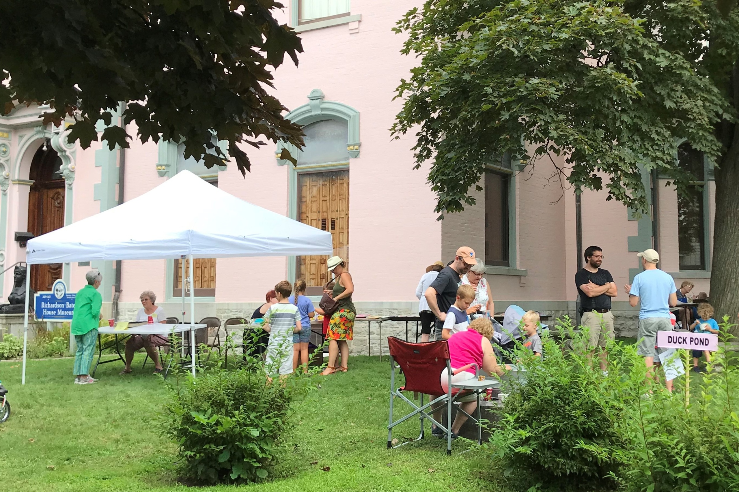 Volunteers and visitors occupy the front and side lawns of the museum of Family Fun Day.