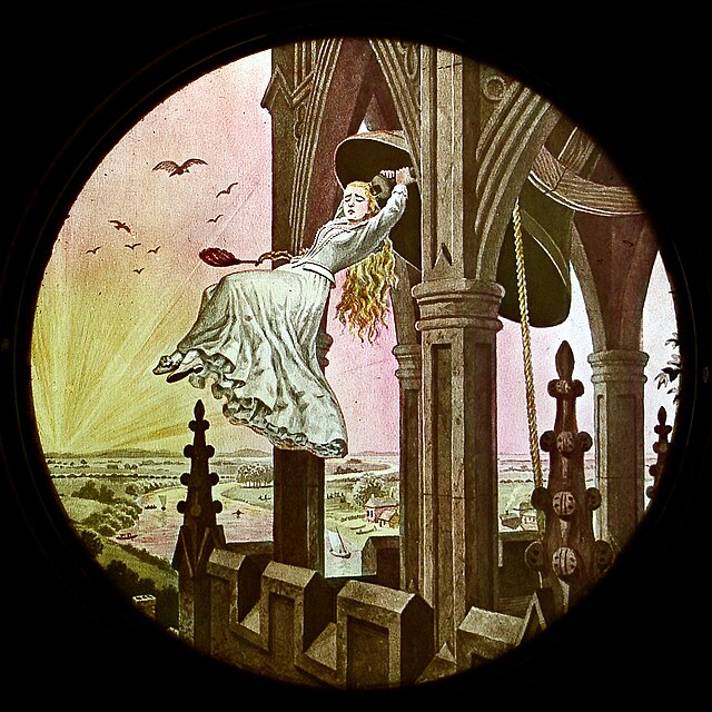 An image of a magic lantern slide from the late 19th century. The circlular image features a young woman suspended between columns with a brightly lite sky and futuristic city landscape behind her.