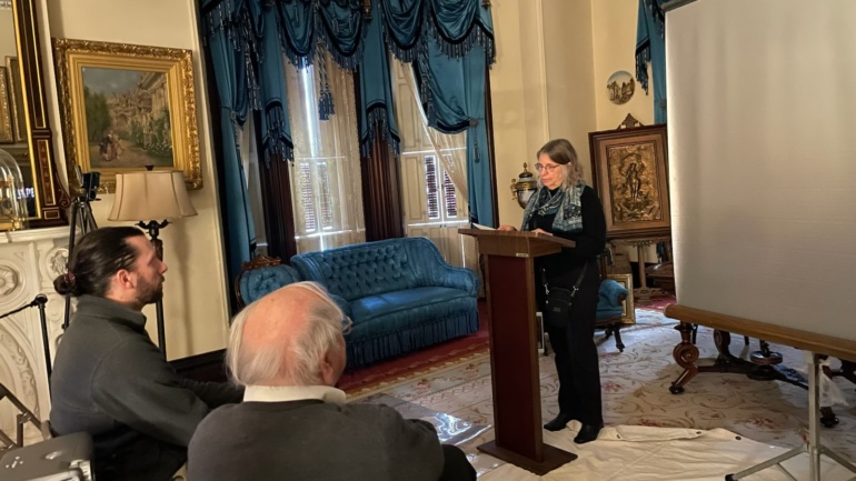 Mary Himes, President of the Scriba Historical Society, prepares her presentation as Michael Pittavino and George DeMass, seated, observe, at the 2025 Medal of Honor Day event.